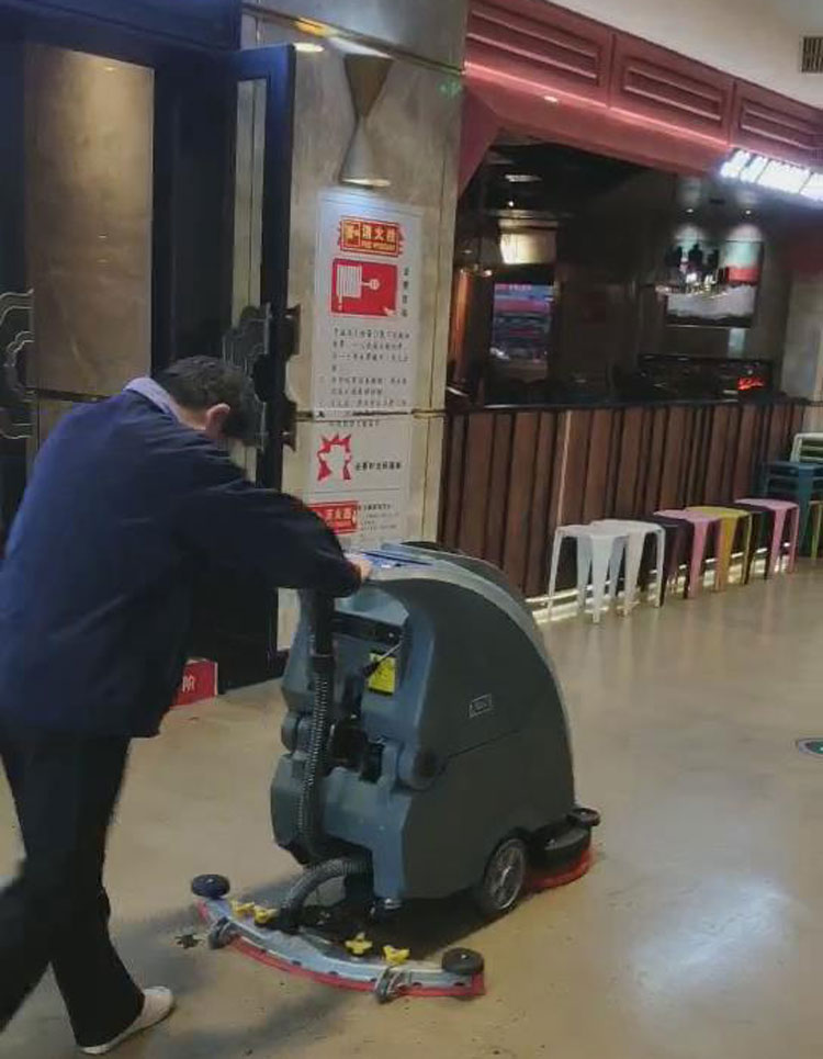 百盛商场的保洁人员对旭洁X750手推式洗地机进行独立操作试用